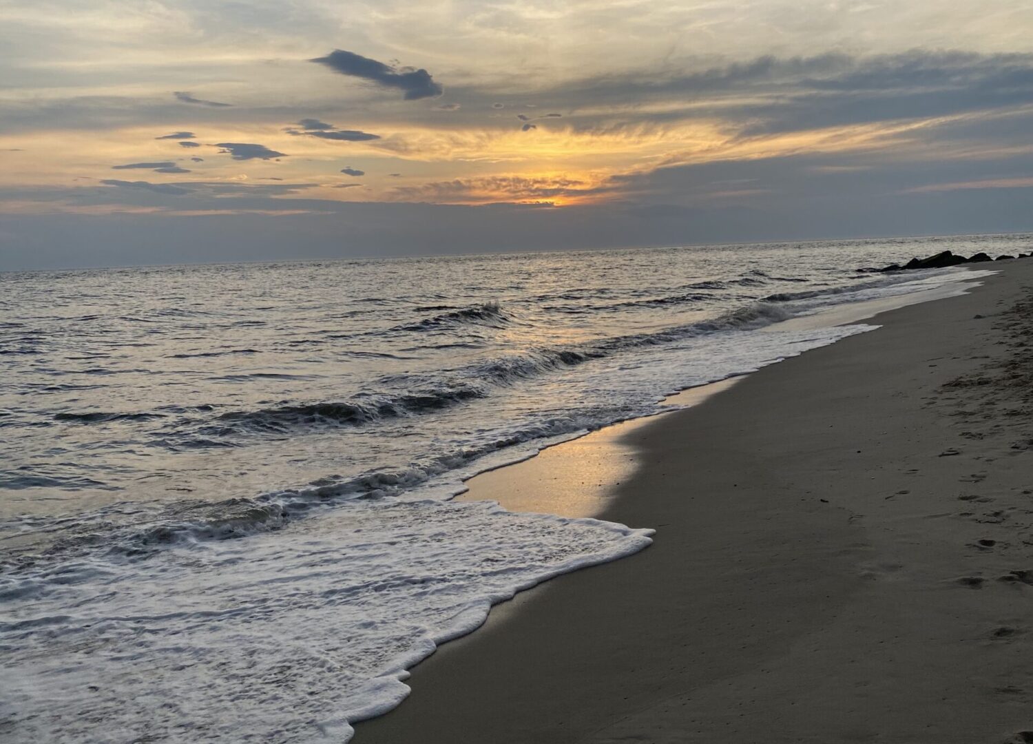 A beach with waves coming in from the ocean.