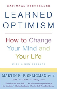 A book cover with the title of " learned optimism ".